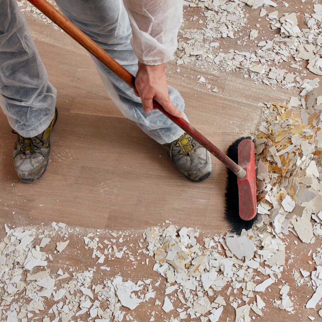 Builder sweeping the floor after renovation